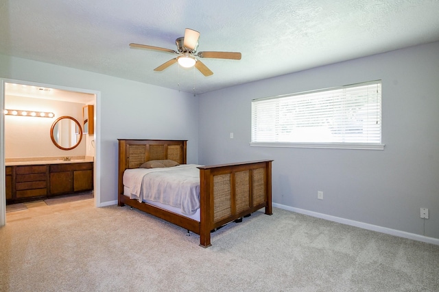 25635 Glen Loch Dr, Spring, TX 77380 - bedroom with light colored carpet, baseboards, ensuite bathroom, a ceiling fan, and a textured ceiling
