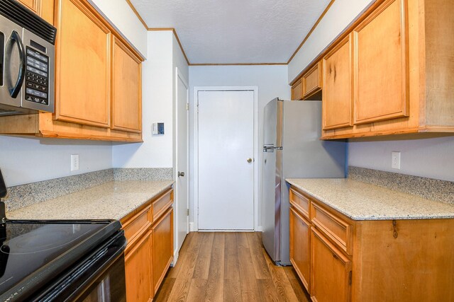 25635 Glen Loch Dr, Spring, TX 77380 - kitchen with appliances with stainless steel finishes, wood finished floors, crown molding, and brown cabinets