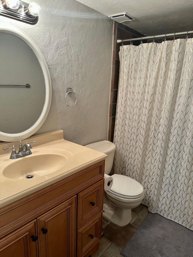 25635 Glen Loch Dr, Spring, TX 77380 - full bathroom with vanity, tile patterned floors, toilet, a textured ceiling, and a shower with curtain