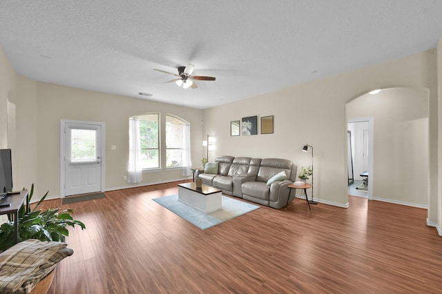 3307 Ellscott Ct, Spring, TX 77386 - living room featuring arched walkways, ceiling fan, wood finished floors, baseboards, and a textured ceiling