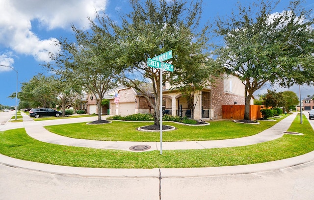2935 Red Maple Dr, Katy, TX 77494 - view of property hidden behind natural elements featuring brick siding, a front lawn, a garage, and concrete driveway