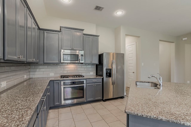 13605 Northline Lake Dr, Houston, TX 77044 - kitchen featuring stainless steel appliances, a sink, decorative backsplash, gray cabinets, and recessed lighting
