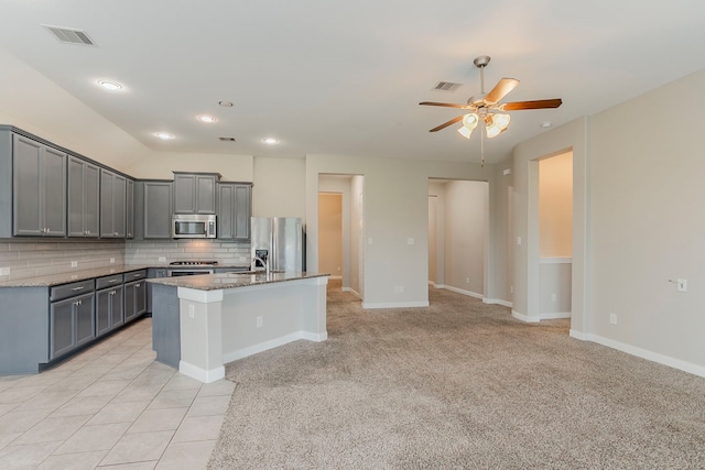 13605 Northline Lake Dr, Houston, TX 77044 - kitchen featuring stainless steel appliances, gray cabinets, backsplash, stone counters, and lofted ceiling