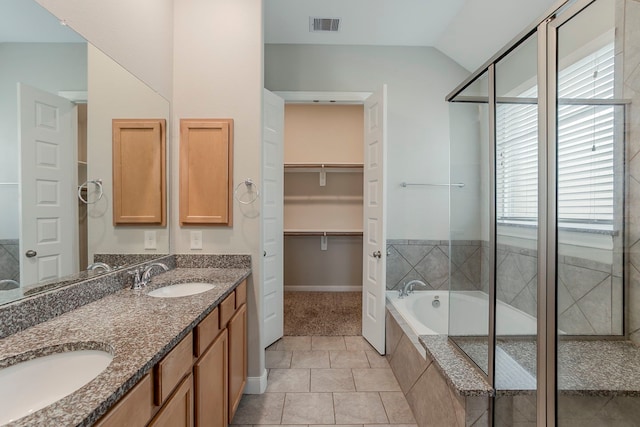 13605 Northline Lake Dr, Houston, TX 77044 - full bathroom featuring vaulted ceiling, baseboards, tiled bath, double vanity, and a shower with door