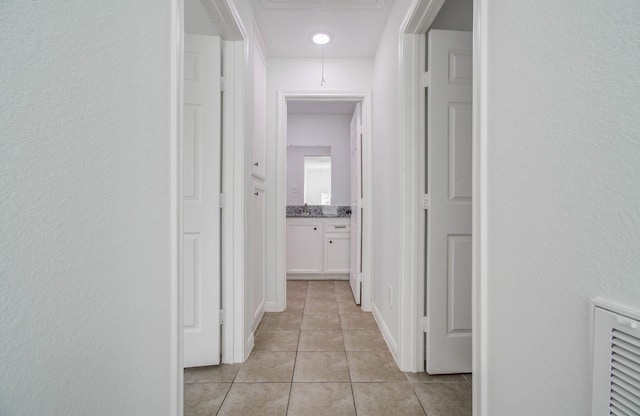 5403 Farley Dr, Houston, TX 77032 - corridor featuring light tile patterned floors, attic access, and a textured wall