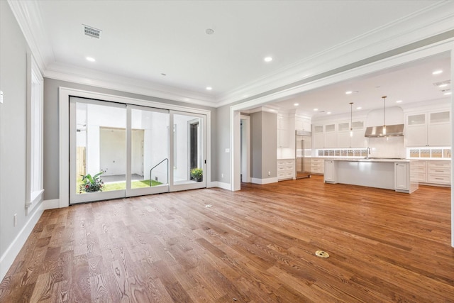 2216 Tangley St, Houston, TX 77005 - unfurnished living room featuring ornamental molding, healthy amount of natural light, baseboards, light wood-style floors, and a sink