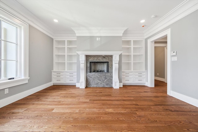 2216 Tangley St, Houston, TX 77005 - unfurnished living room featuring ornamental molding, built in shelves, a high end fireplace, baseboards, and wood finished floors