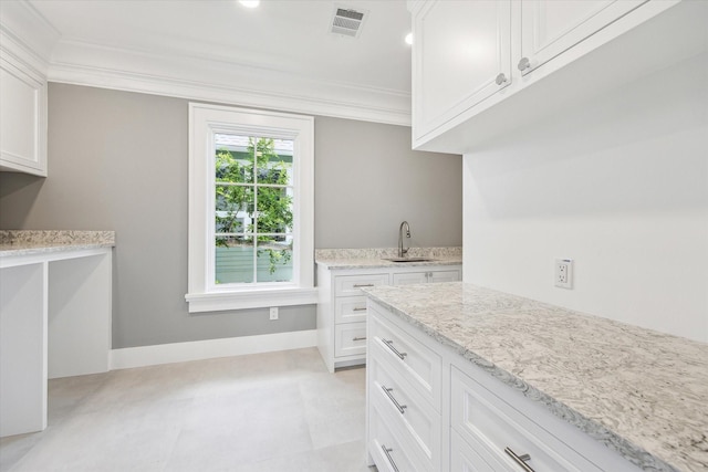2216 Tangley St, Houston, TX 77005 - kitchen featuring crown molding, a sink, light stone counters, white cabinetry, and baseboards