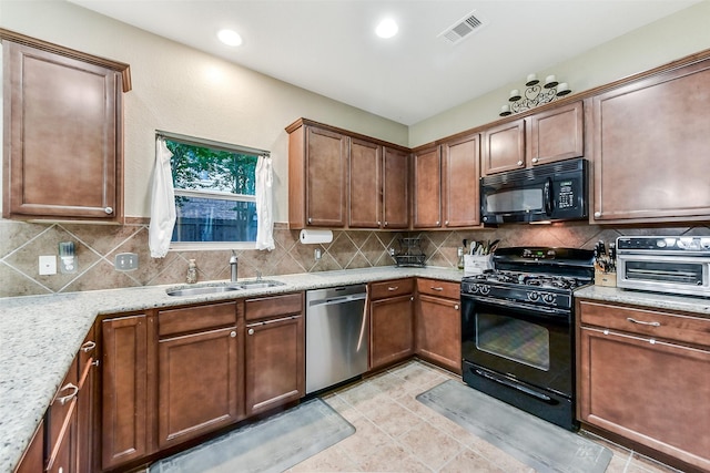 1703 Balsam Spruce Cir, Conroe, TX 77301 - kitchen with black appliances, decorative backsplash, a sink, light stone countertops, and recessed lighting