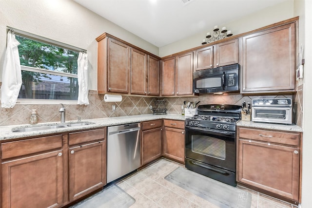 1703 Balsam Spruce Cir, Conroe, TX 77301 - kitchen featuring black appliances, a sink, backsplash, light stone counters, and light tile patterned floors