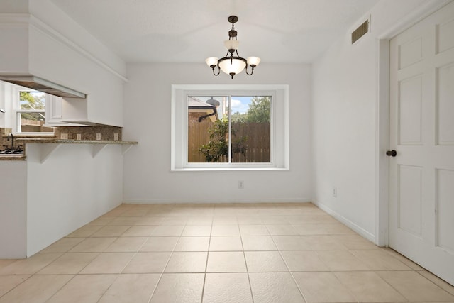 31111 Alice Ln, Tomball, TX 77375 - unfurnished dining area featuring a chandelier and light tile patterned floors