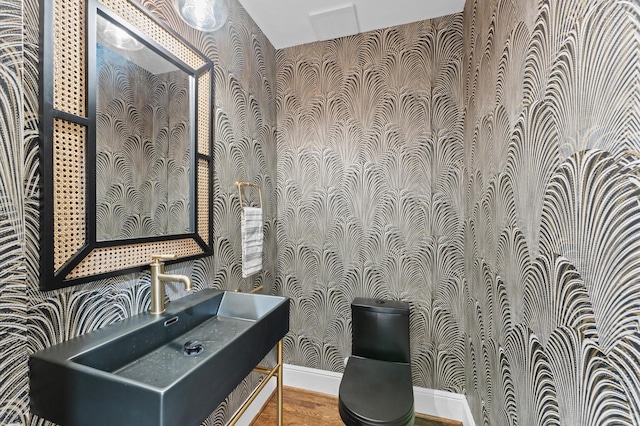 304 Bayland Ave, Houston, TX 77009 - half bath featuring wallpapered walls, toilet, baseboards, vanity, and wood finished floors
