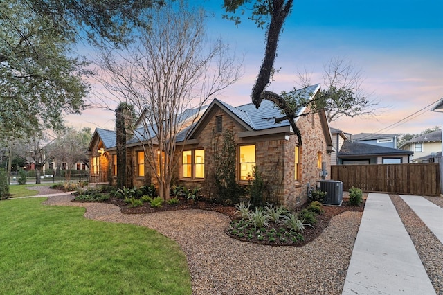 304 Bayland Ave, Houston, TX 77009 - back of property at dusk featuring cooling unit and stone siding