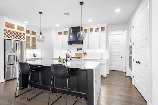 15838 Weston Ridge Dr, Humble, TX 77346 - kitchen featuring stainless steel appliances, premium range hood, dark wood-style flooring, recessed lighting, and a center island with sink