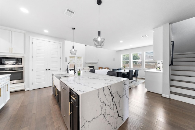 15838 Weston Ridge Dr, Humble, TX 77346 - kitchen featuring stainless steel appliances, recessed lighting, white cabinetry, dark wood finished floors, and a sink