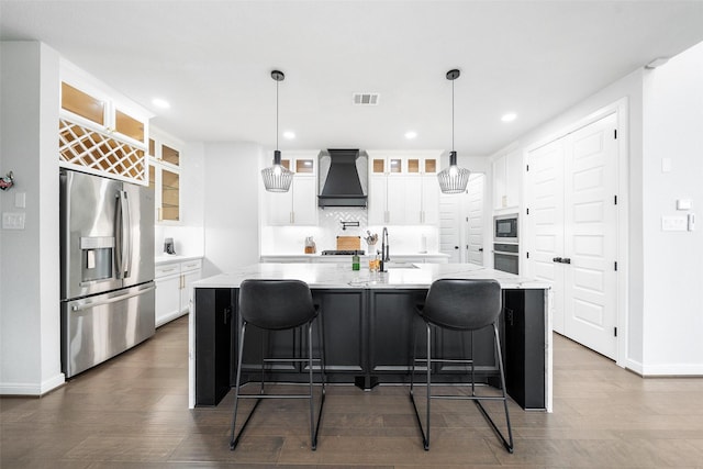 15838 Weston Ridge Dr, Humble, TX 77346 - kitchen with appliances with stainless steel finishes, premium range hood, white cabinetry, dark wood-style flooring, and recessed lighting