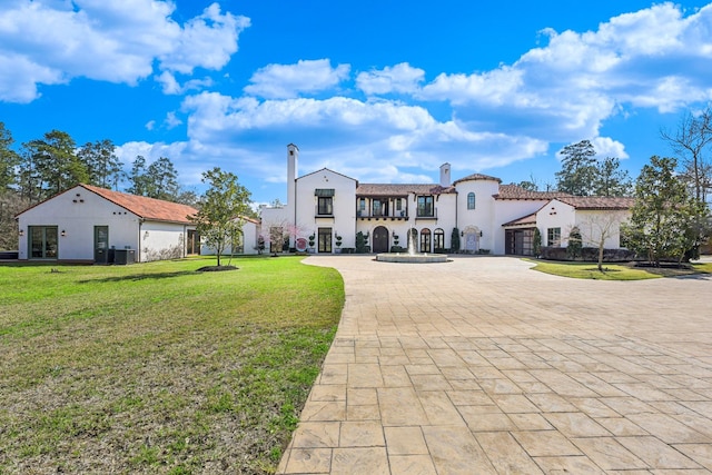 7519 Red Bay Cir, Magnolia, TX 77354 - rear view of house with curved driveway, a yard, a garage, and stucco siding