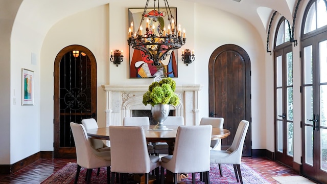 7519 Red Bay Cir, Magnolia, TX 77354 - dining room with baseboards, arched walkways, french doors, a chandelier, and high vaulted ceiling