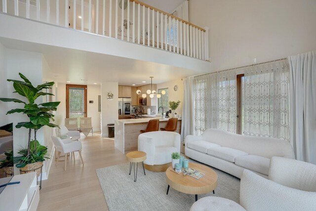 7519 Red Bay Cir, Magnolia, TX 77354 - living area with light wood finished floors, a high ceiling, a chandelier, recessed lighting, and baseboards