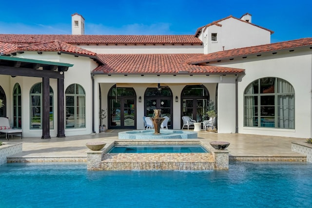 7519 Red Bay Cir, Magnolia, TX 77354 - rear view of house featuring a patio area, french doors, an outdoor pool, stucco siding, and a tiled roof