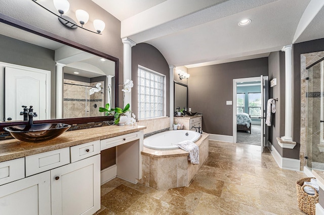 21806 W Firemist Ct, Cypress, TX 77433 - ensuite bathroom with decorative columns, a shower stall, stone tile flooring, and a garden tub