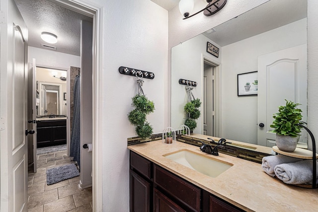 21806 W Firemist Ct, Cypress, TX 77433 - full bath with stone tile flooring, a textured ceiling, vanity, and curtained shower
