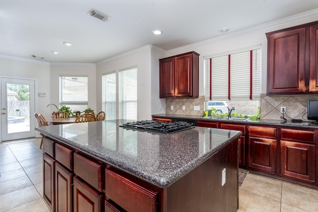 11510 Maple Falls Dr, Tomball, TX 77377 - kitchen featuring black gas cooktop, dark brown cabinets, a sink, a kitchen island, and tasteful backsplash