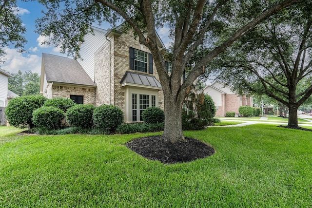 11510 Maple Falls Dr, Tomball, TX 77377 - view of front of home featuring brick siding, a front lawn, and a standing seam roof