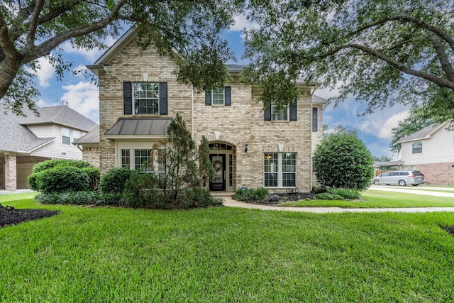 11510 Maple Falls Dr, Tomball, TX 77377 - traditional-style house featuring a front lawn, brick siding, and a standing seam roof
