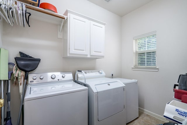 11510 Maple Falls Dr, Tomball, TX 77377 - laundry room with washing machine and clothes dryer, cabinet space, light tile patterned floors, and baseboards
