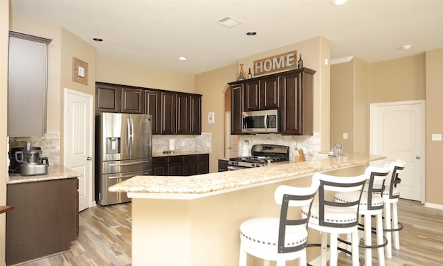 15727 W Chamfer Way, Crosby, TX 77532 - kitchen featuring appliances with stainless steel finishes, backsplash, light wood-style flooring, and recessed lighting