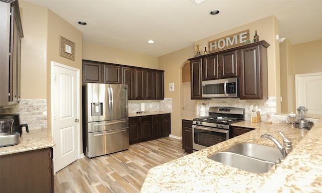 15727 W Chamfer Way, Crosby, TX 77532 - kitchen with stainless steel appliances, a sink, dark brown cabinets, tasteful backsplash, and recessed lighting