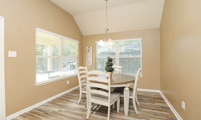 15727 W Chamfer Way, Crosby, TX 77532 - dining space with light wood-style flooring, lofted ceiling, baseboards, and a chandelier