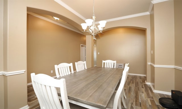 15727 W Chamfer Way, Crosby, TX 77532 - dining room featuring arched walkways, a chandelier, baseboards, ornamental molding, and wood finished floors