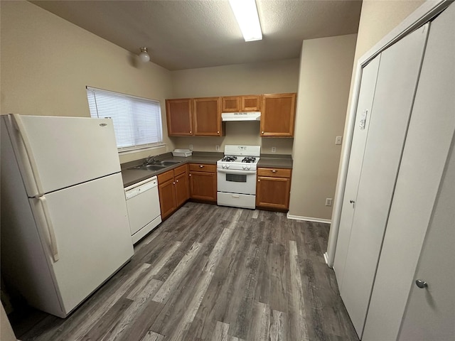 6410 Provident Green Dr, Katy, TX 77449 - kitchen featuring white appliances, dark wood-style floors, under cabinet range hood, dark countertops, and a sink