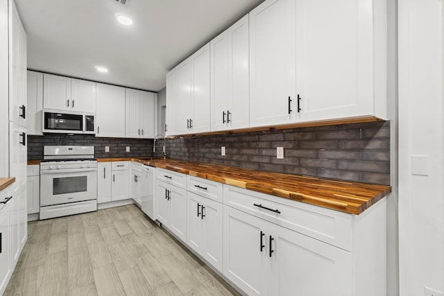 5202 Libbey Ln, Houston, TX 77092 - kitchen featuring wooden counters, white appliances, decorative backsplash, a sink, and white cabinetry