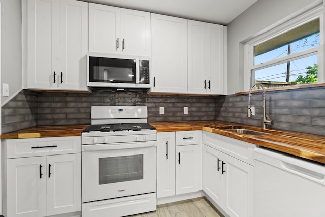 5202 Libbey Ln, Houston, TX 77092 - kitchen with butcher block countertops, white appliances, a sink, and white cabinets