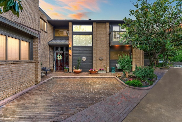 8800 Woodway Dr Unit 12, Houston, TX 77063 - exterior entry at dusk with brick siding and a balcony