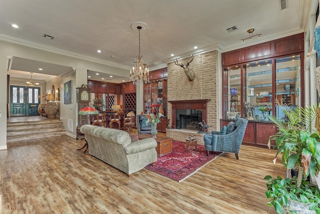 8800 Woodway Dr Unit 12, Houston, TX 77063 - living area with a chandelier, light wood-style floors, ornamental molding, a brick fireplace, and baseboards