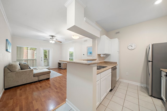 1330 Old Spanish Trl Unit 5203, Houston, TX 77054 - kitchen with appliances with stainless steel finishes, white cabinets, ornamental molding, open floor plan, and a peninsula