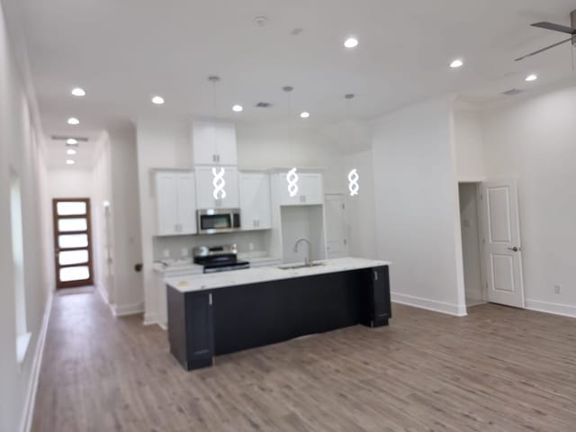 4539 Rosemont St A/B, Unit A/B Houston, TX 77051 - kitchen with appliances with stainless steel finishes, a sink, light wood-style flooring, baseboards, and a spacious island