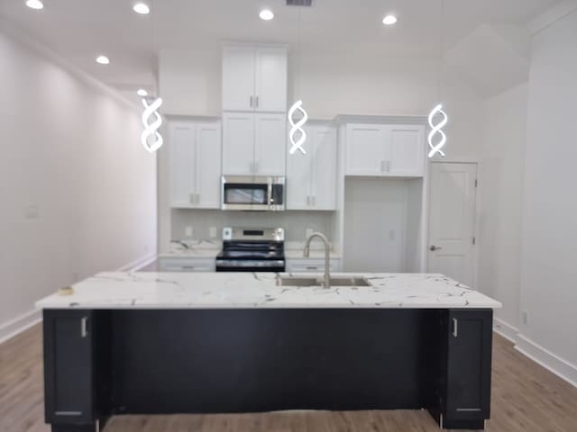 4539 Rosemont St A/B, Unit A/B Houston, TX 77051 - kitchen featuring appliances with stainless steel finishes, a sink, white cabinetry, a large island with sink, and recessed lighting