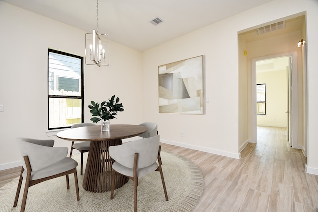 90 Burress St Unit A, Houston, TX 77022 - dining room featuring a chandelier, light wood-style floors, and baseboards