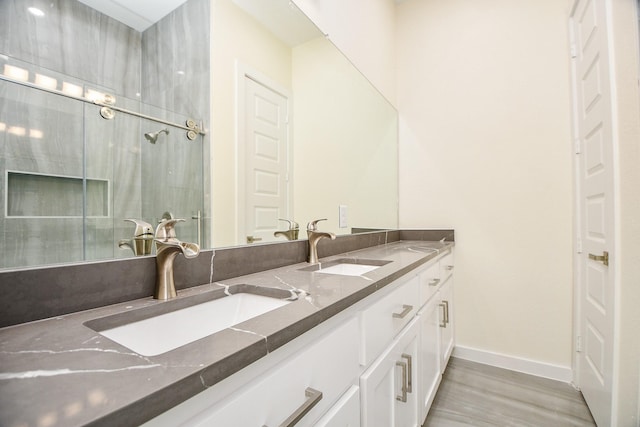 90 Burress St Unit A, Houston, TX 77022 - bathroom with baseboards, double vanity, and wood finished floors