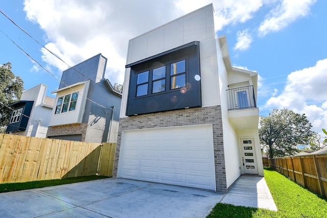 90 Burress St Unit A, Houston, TX 77022 - view of front of home with a garage, driveway, brick siding, and stucco siding