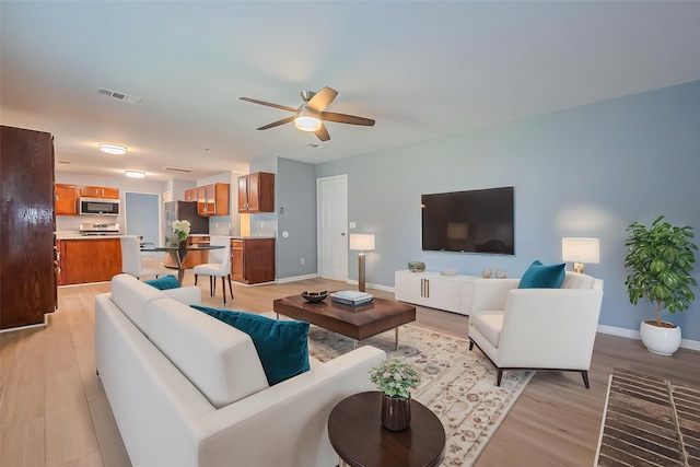 1010 Cheyenne Meadows Dr, Katy, TX 77450 - living area featuring ceiling fan, light wood-style floors, and baseboards