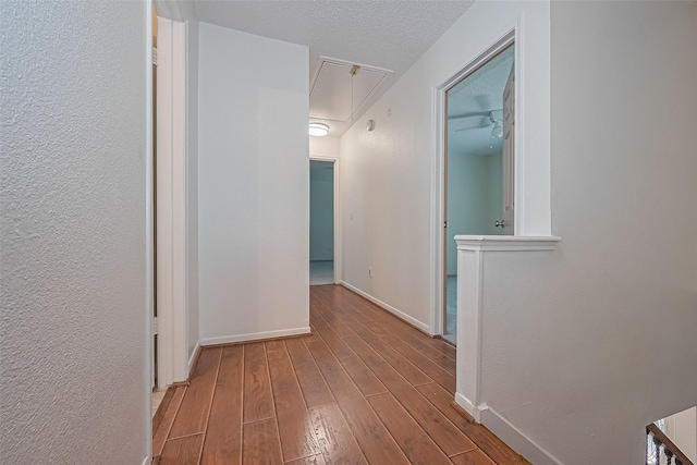 1010 Cheyenne Meadows Dr, Katy, TX 77450 - hallway with attic access, baseboards, wood finished floors, and a textured ceiling
