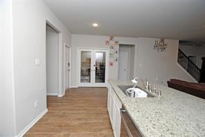 4619 Ehrlich Ct, Rosenberg, TX 77471 - kitchen featuring white cabinetry, a sink, light wood-style flooring, recessed lighting, and baseboards
