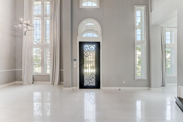 3650 Sage Hollow Dr, Spring, TX 77386 - tiled foyer featuring a towering ceiling, a chandelier, and baseboards