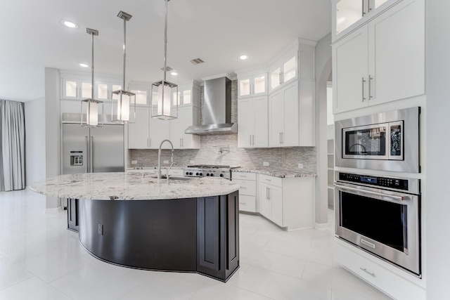 3650 Sage Hollow Dr, Spring, TX 77386 - kitchen featuring appliances with stainless steel finishes, wall chimney exhaust hood, a sink, tasteful backsplash, and light stone counters